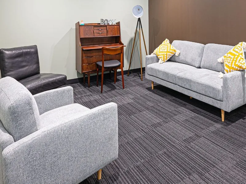 Deluxe suite with grey sofa and writing desk